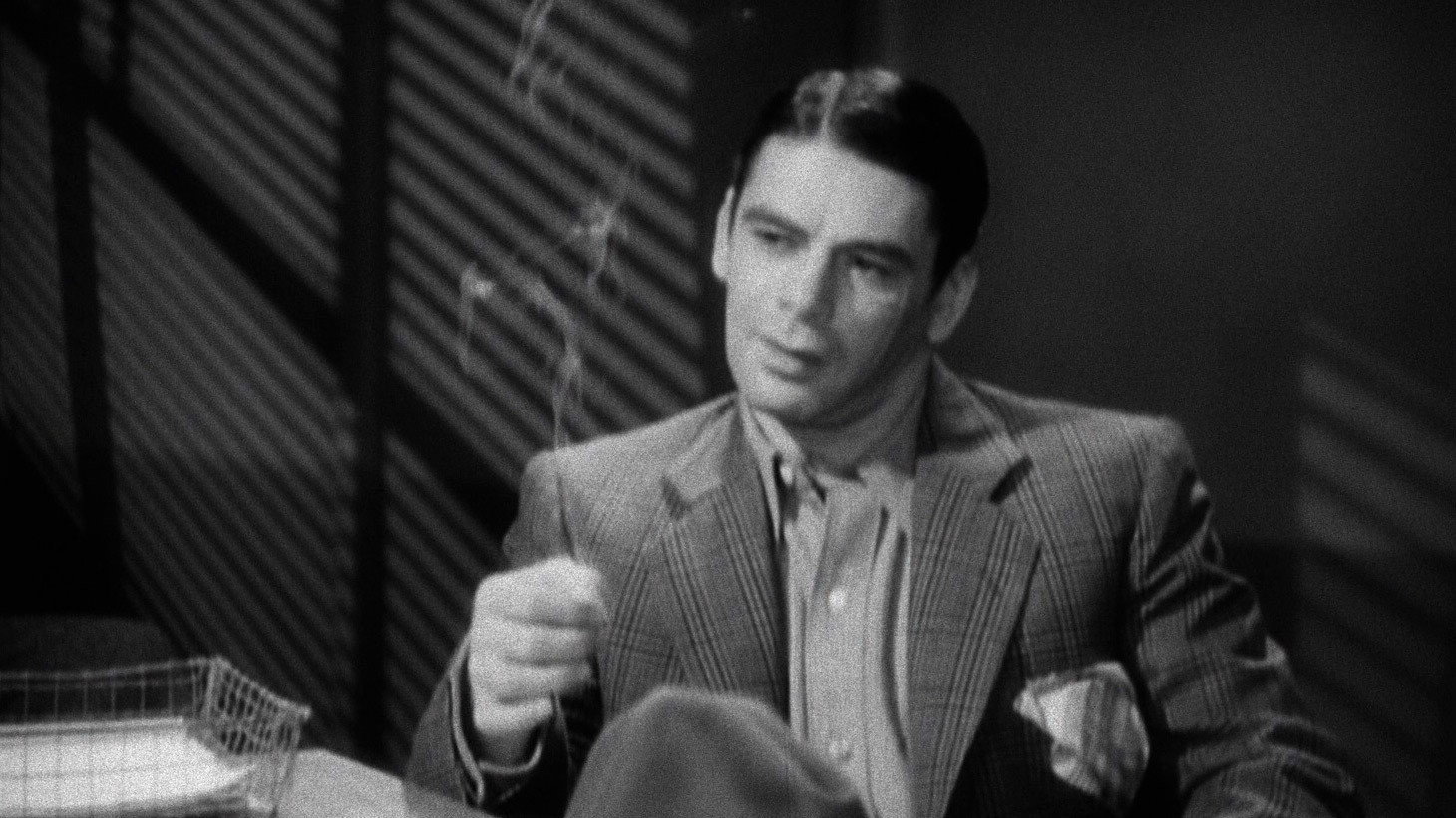 Paul Muni smokes a cigarette in Scarface