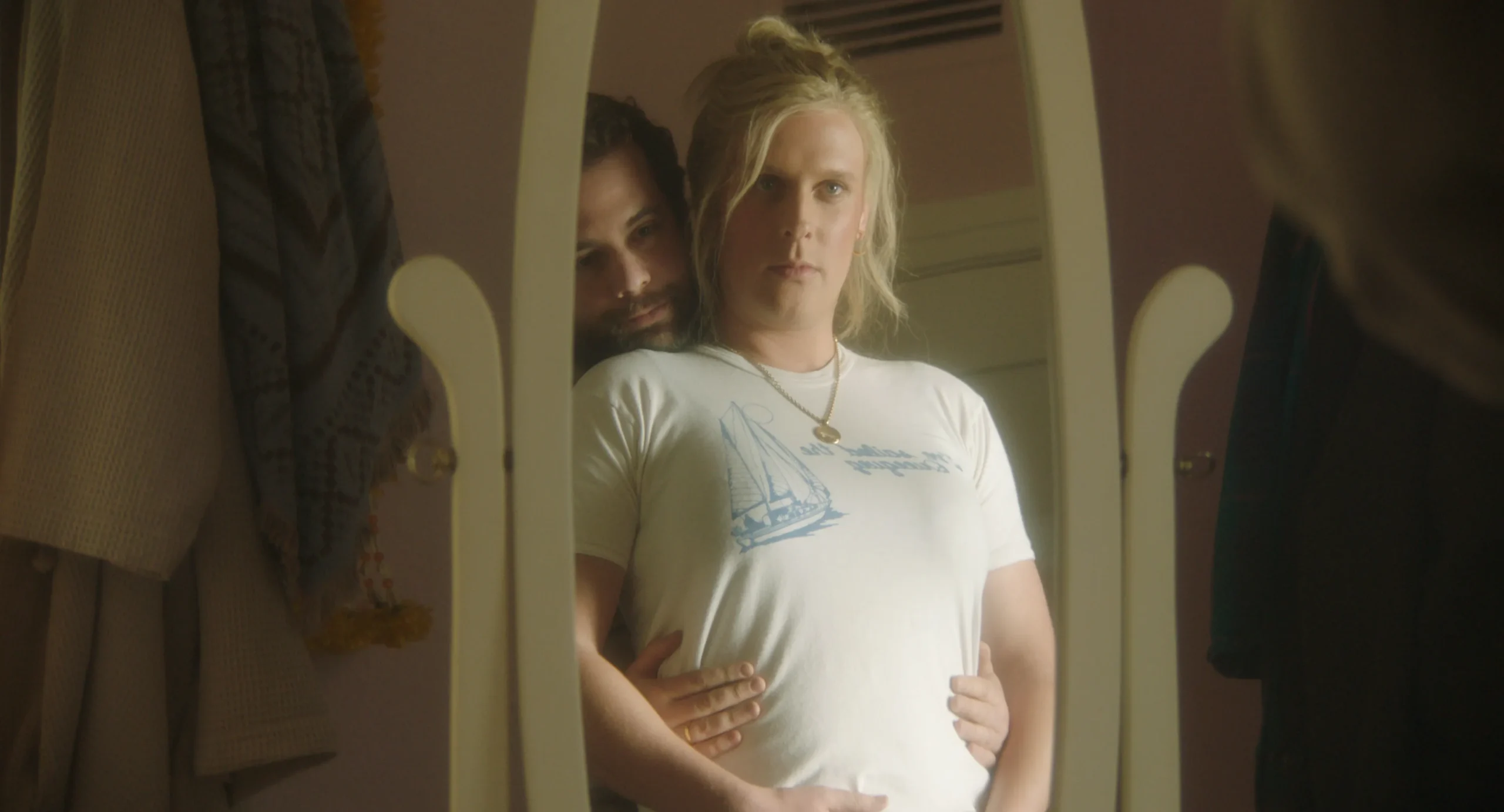 John Early as Maddie, regarding herself critically in the mirror while her partner played by Eric Rahill worships her body.
