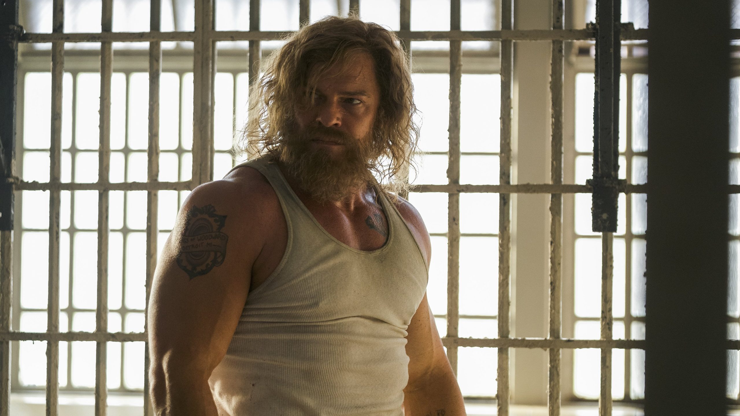 John Miller, played by Alan Ritchson, stalks his jail cell in the movie Motor City.