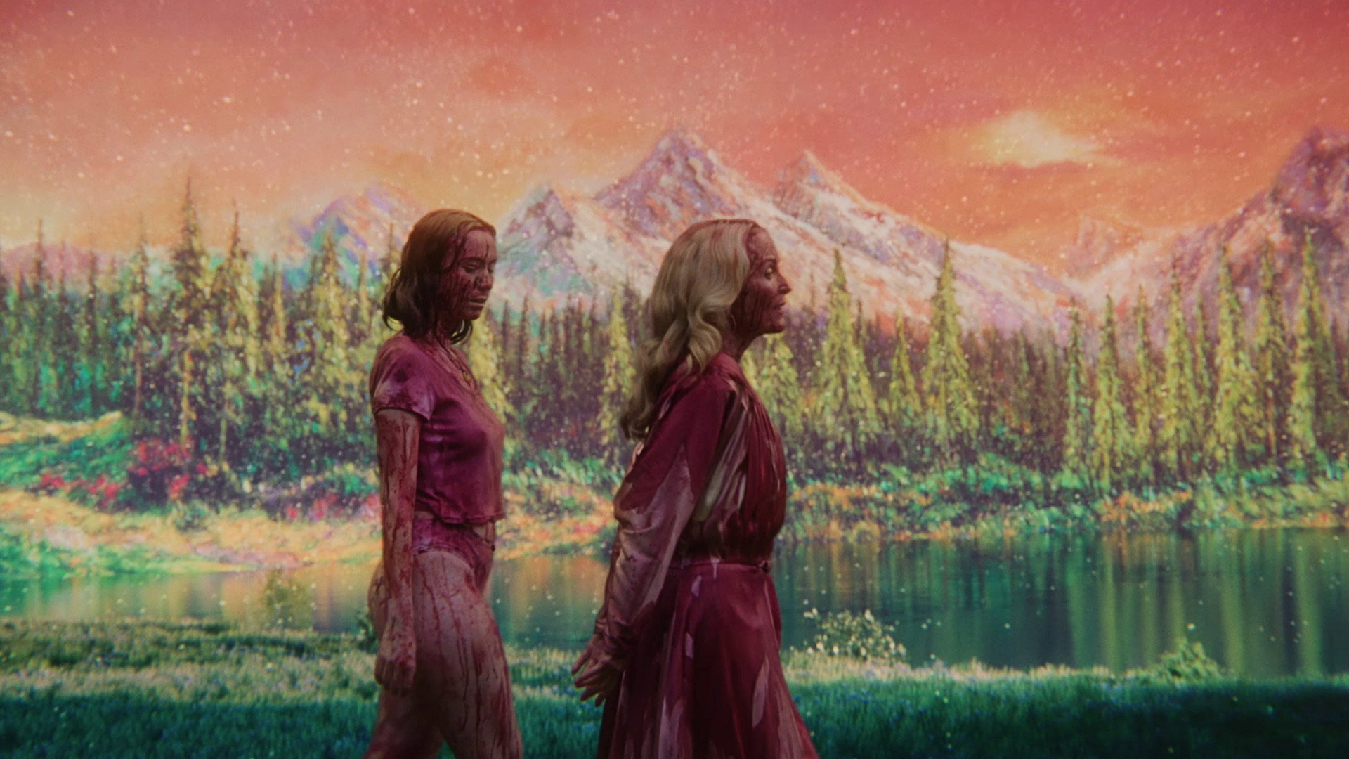 A blood-soaked Hannah Einbinder and Gillian Anderson take a stroll in front of a beautiful matte painting of a meadow and a mountain range.